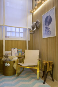Quarto de bebê acolhedor com paleta de madeira, branco, azul e amarelo em projeto de interiores